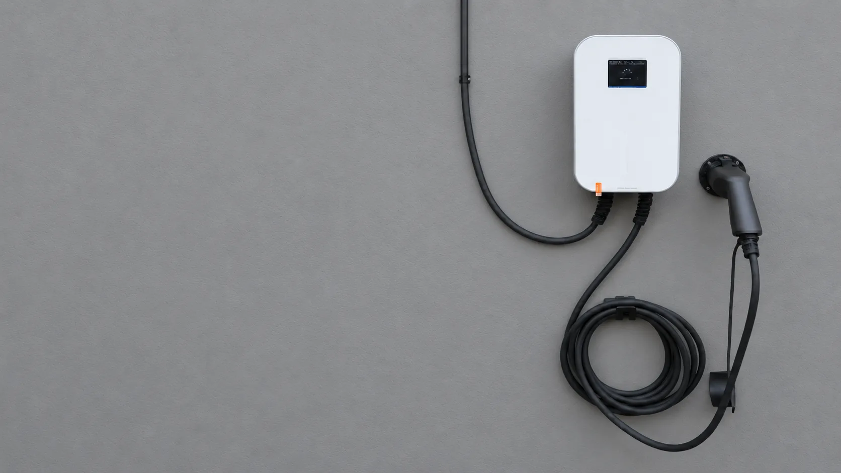 Auto eléctrico conectado a un cargador de pared en un garaje